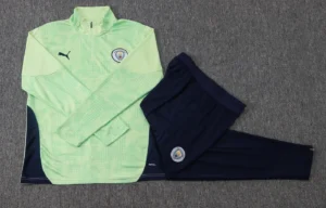 Green quarter-zip football training top and trousers shown in a flat lay